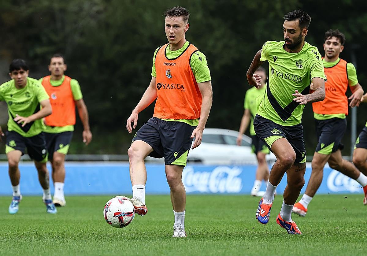 Turrientes juega el balón durante un entrenamiento en Zubieta ante la presencia de Brais.