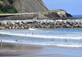 Algunas personas se bañan en la playa de Deba.