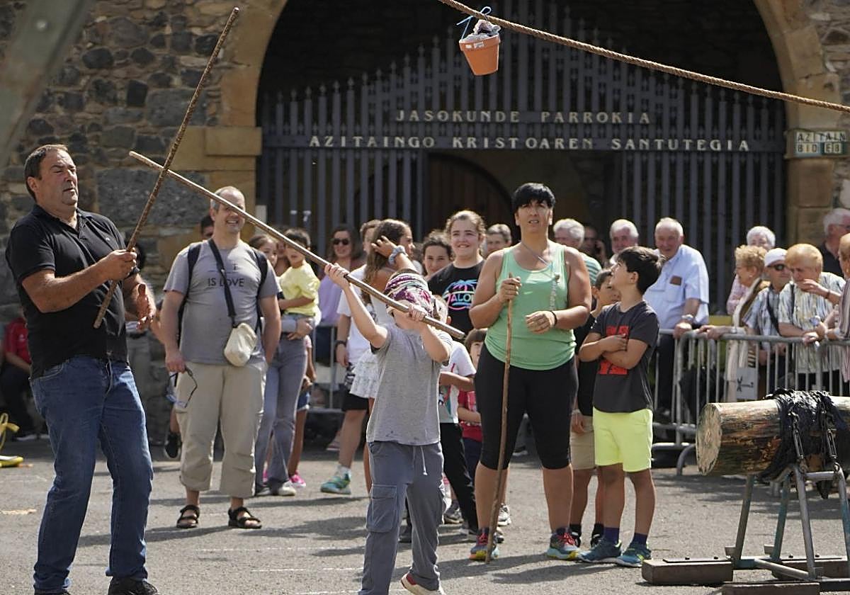 Niños y jóvenes intentaron romper la hucha, tradición arraigada en el barrio de Azitain.