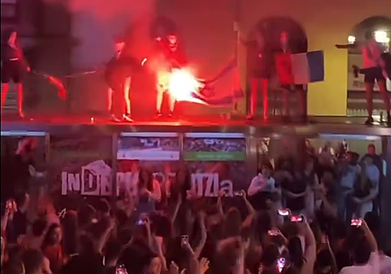 Unos jóvenes queman las banderas frente a la txosna Kaskagorri en Bilbao.