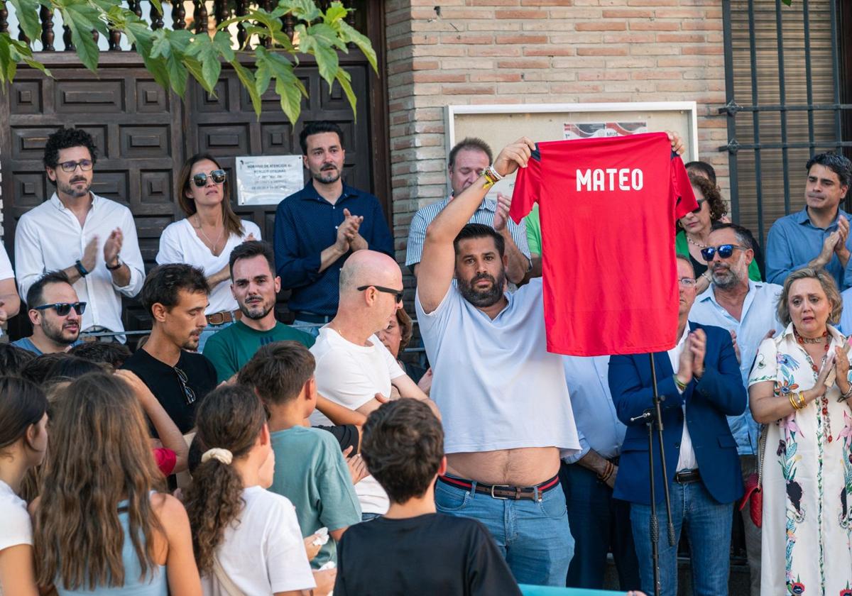 Amigos y familiares del niño asesinado muestran una camiseta con su nombre, durante el minuto de silencio por sul asesinato ante el Ayuntamiento de Mocejón.