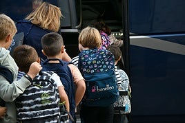 Varios niños suben a un autobús escolar en Eibar.