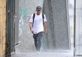 El chaparrón ha pillado desprevenido a este joven en Irun.