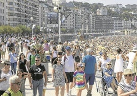 El paseo y la playa de La Concha, abarrotados ayer al mediodía, antes de que por la tarde empezara a llover. Una imagen que cada año se repite con más frecuencia.