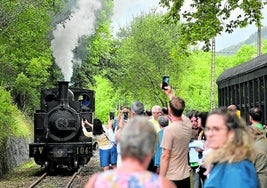 Los visitantes del museo aguardan en la estación a la locomotora de vapor mientras la fotografían.