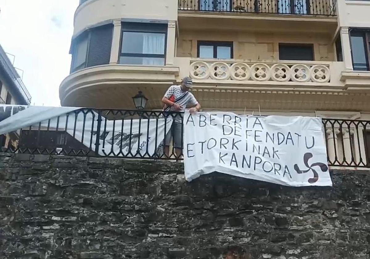 Retiran una pancarta del muelle durante la Aste Nagusia de Donostia.
