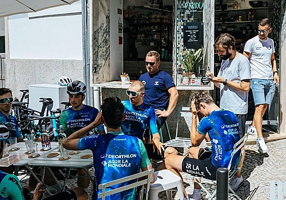 Los ciclistas del Decathlon, relajados tomando algo en una terraza con Ben O'Connor en primer plano, de espaldas.