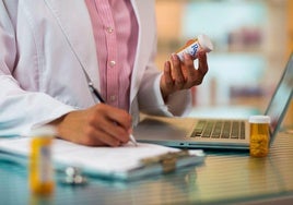 Un médico prescribe la receta de un medicamento.