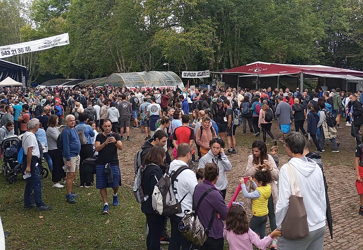 Imagen principal - Arriba, las txosnas estuvieron muy concurridas. Debajo, a la izquierda, una familia celebra la comida en Arrate. A su lado, la tradición de colocar velas. 