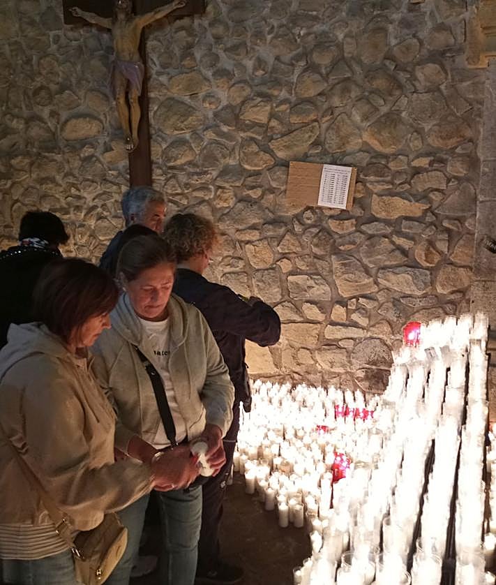 Imagen secundaria 2 - Arriba, las txosnas estuvieron muy concurridas. Debajo, a la izquierda, una familia celebra la comida en Arrate. A su lado, la tradición de colocar velas. 