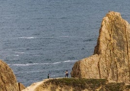 Dos personas recorren uno de los acantilados de la Costa Quebrada en Cantabria.