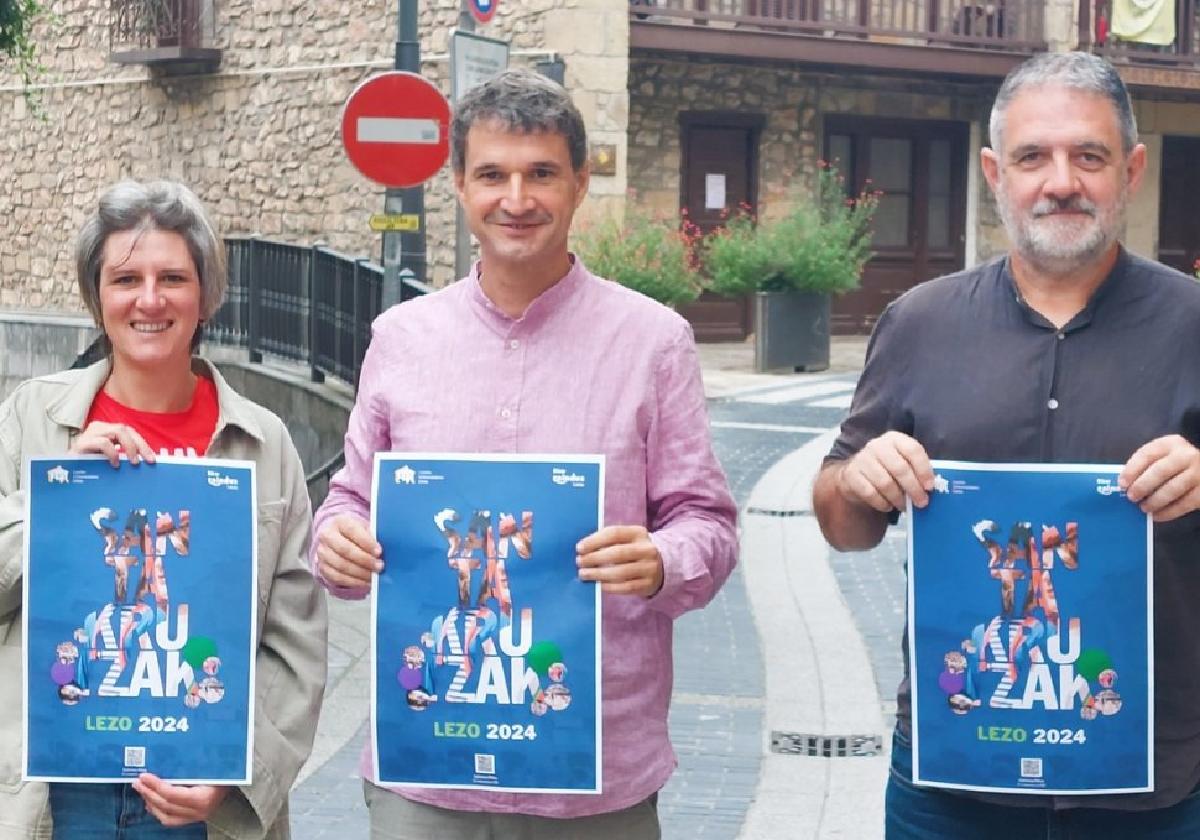 Mireia Kuesta, Mikel Arruti y Jon Legorburu con el cartel anunciador de las fiesta de Santakrutz 2024.