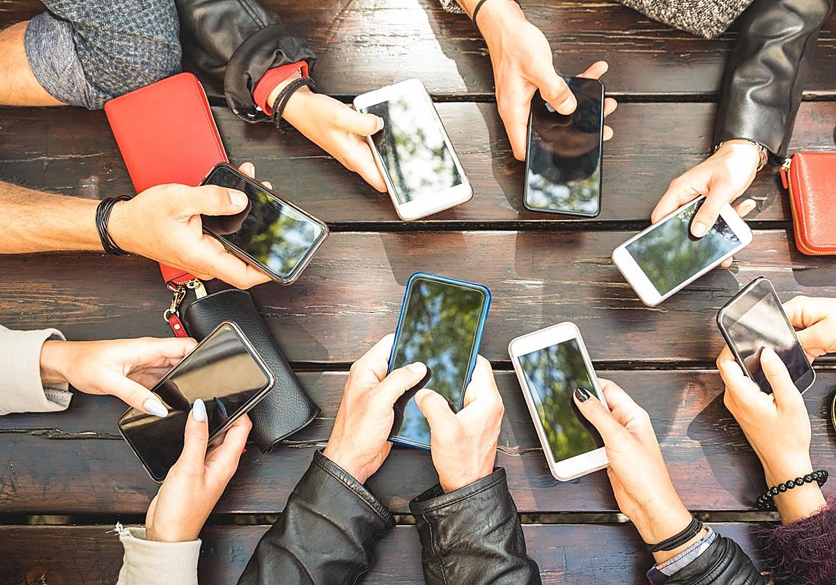 Varios chavales consultan sus móviles.