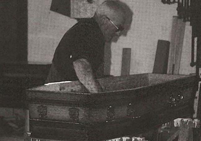 Un carpintero fabrica un ataúd.