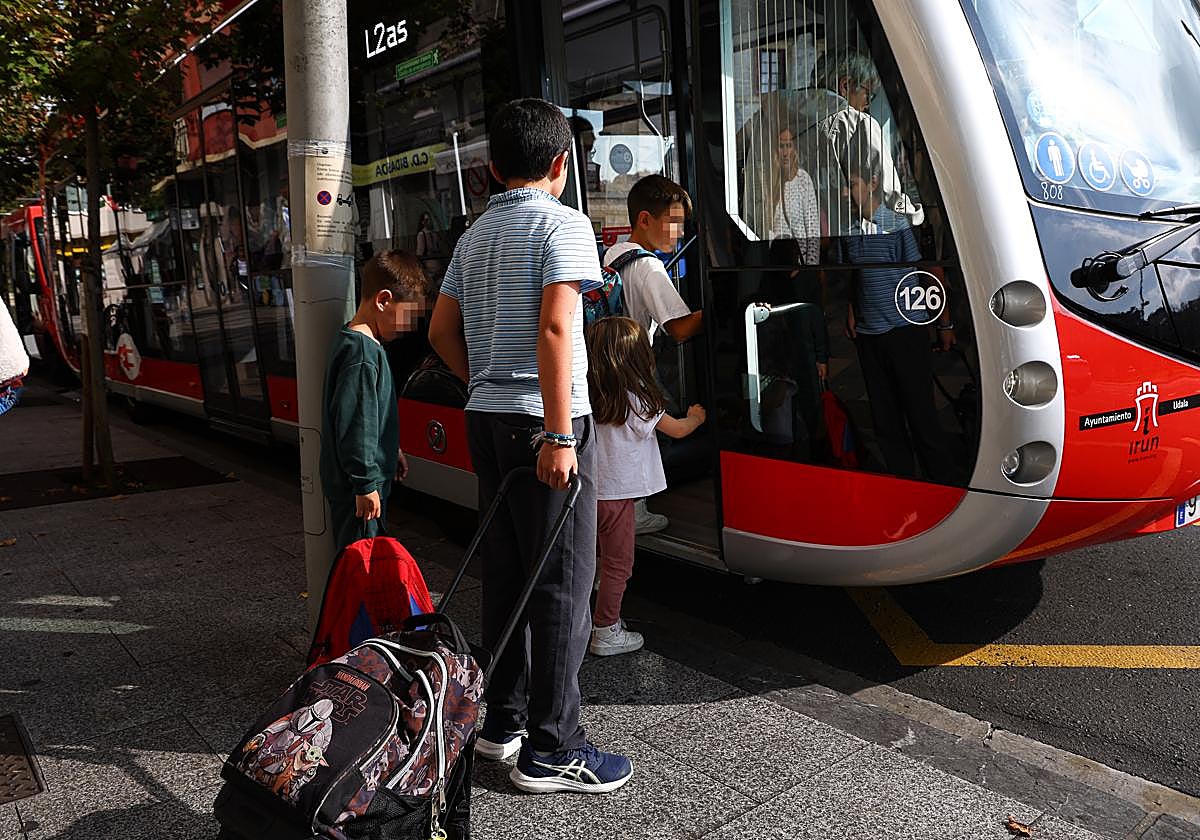 Escolares menores de 12 años se suben a un autobús urbano en Irun.