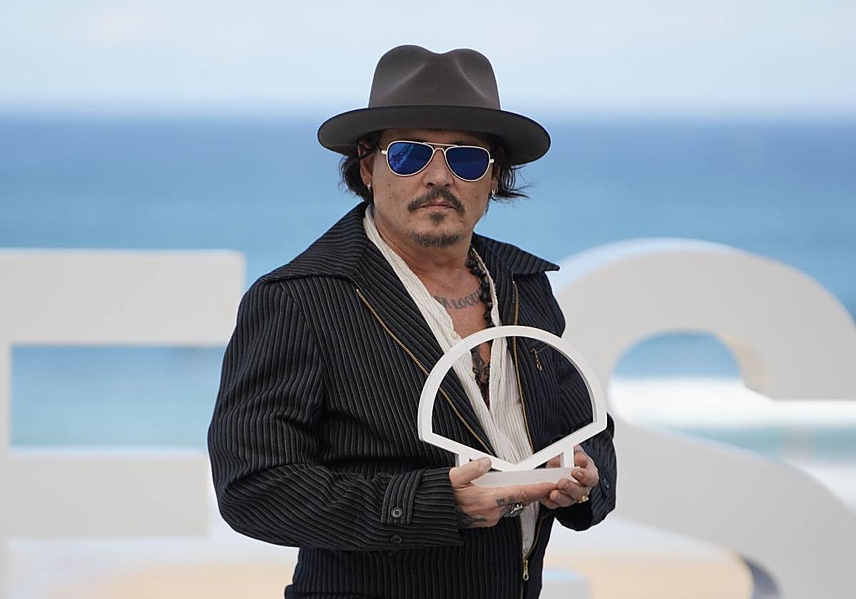 Johnny Depp posa con el logo del Zinemaldia durante el photocall de su película.