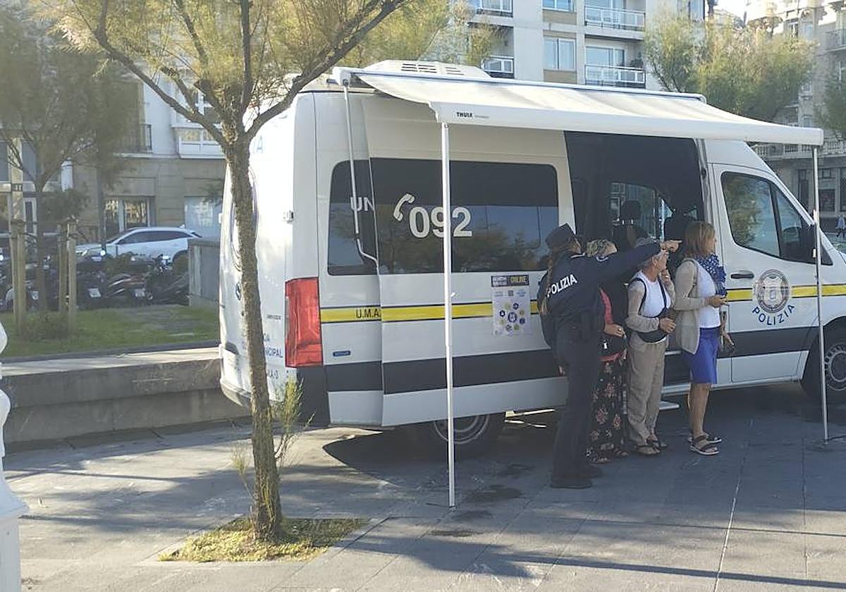 Una agente de la Guardia Municipal atiende a tres mujeres en la plaza Cervantes.