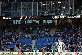 Dos jugadores del Anderlecht piden a sus aficionados que dejen de lanzar objetos.