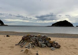 Los recientes episodios meteorológicos extremos han aflorado un manto de piedras en la playa de Ondarreta. La orilla está plagada de pequeños cascotes, como puede apreciarse con marea baja, pero también han aparecido bloques de mayor tamaño que alguien se ha dedicado a apilar sobre la arena, formando un muro que ayer sorprendió a paseantes y bañistas.