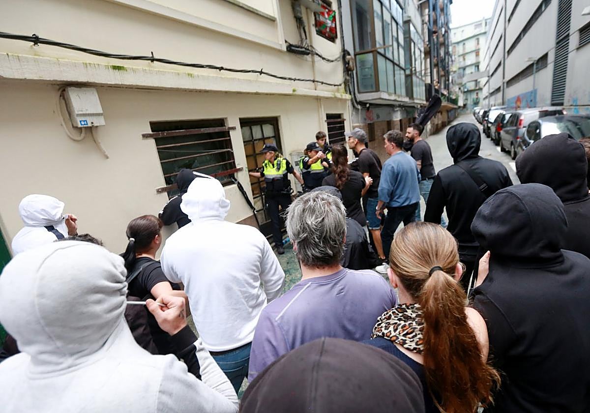 Agentes de la Policía Local y manifestantes ante el local ocupado.