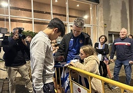 Take Cubo firma un autógrafo a Laura, una joven realista, acompañada por su padre Narcís, en el hotel donde se hospeda la Real en Girona.