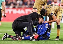 Álex Remiro se echa la mano a la rodilla tras salir a por un balón.