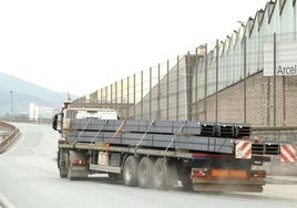 Un camión con vigas circula junto a la planta de ArcelorMittal en Olaberria.