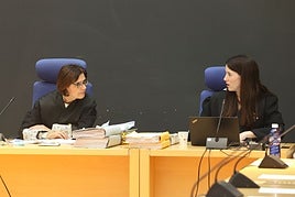 La magistrada presidenta y la letrada conversan antes del comienzo de una sesión del juicio.