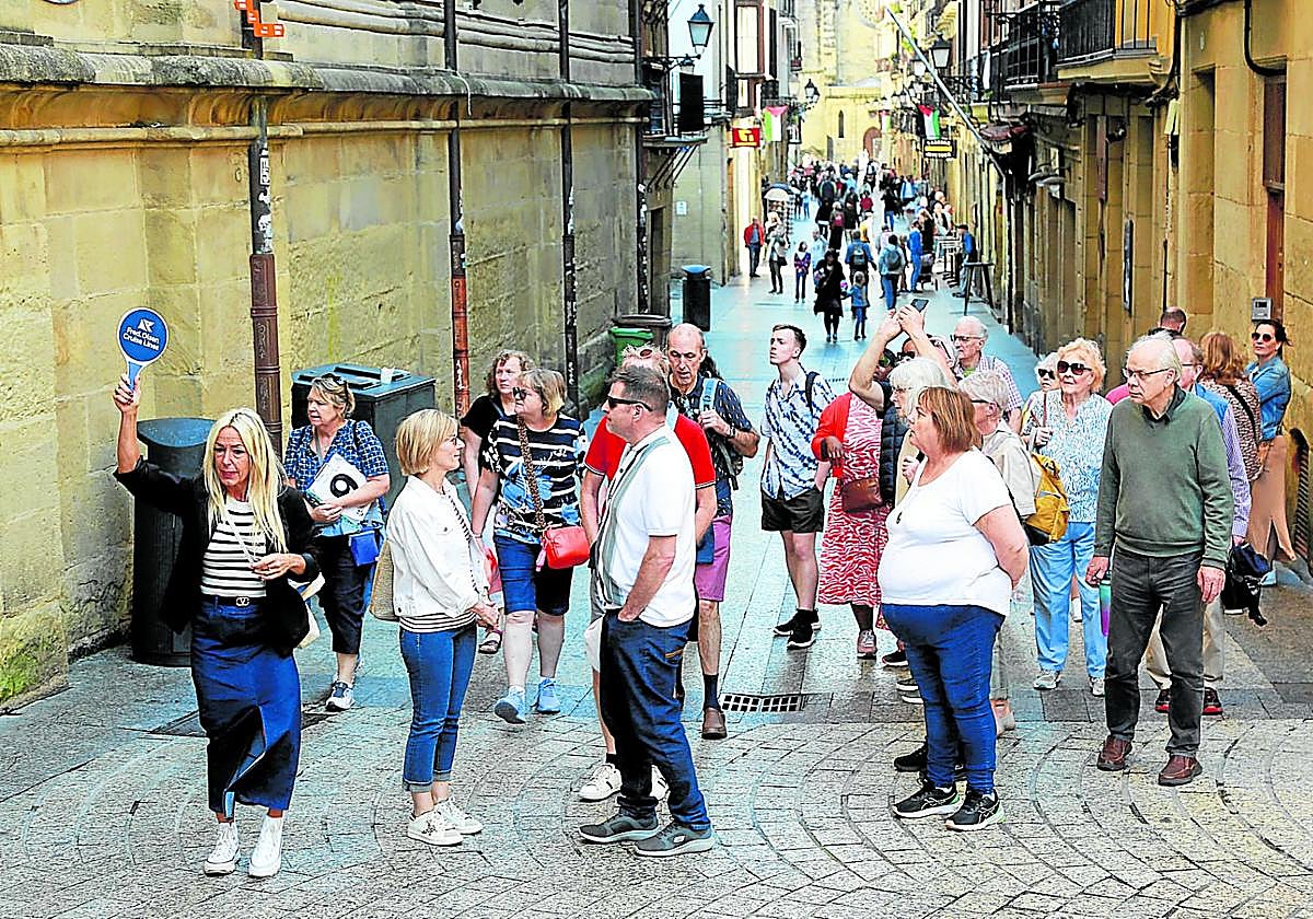 Una guía turística conduce a un grupo de visitantes por la calle 31 de Agosto ayer al mediodía en Donostia.