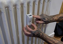 Un trabajador instala un contador individual de calefacción en un domicilio.