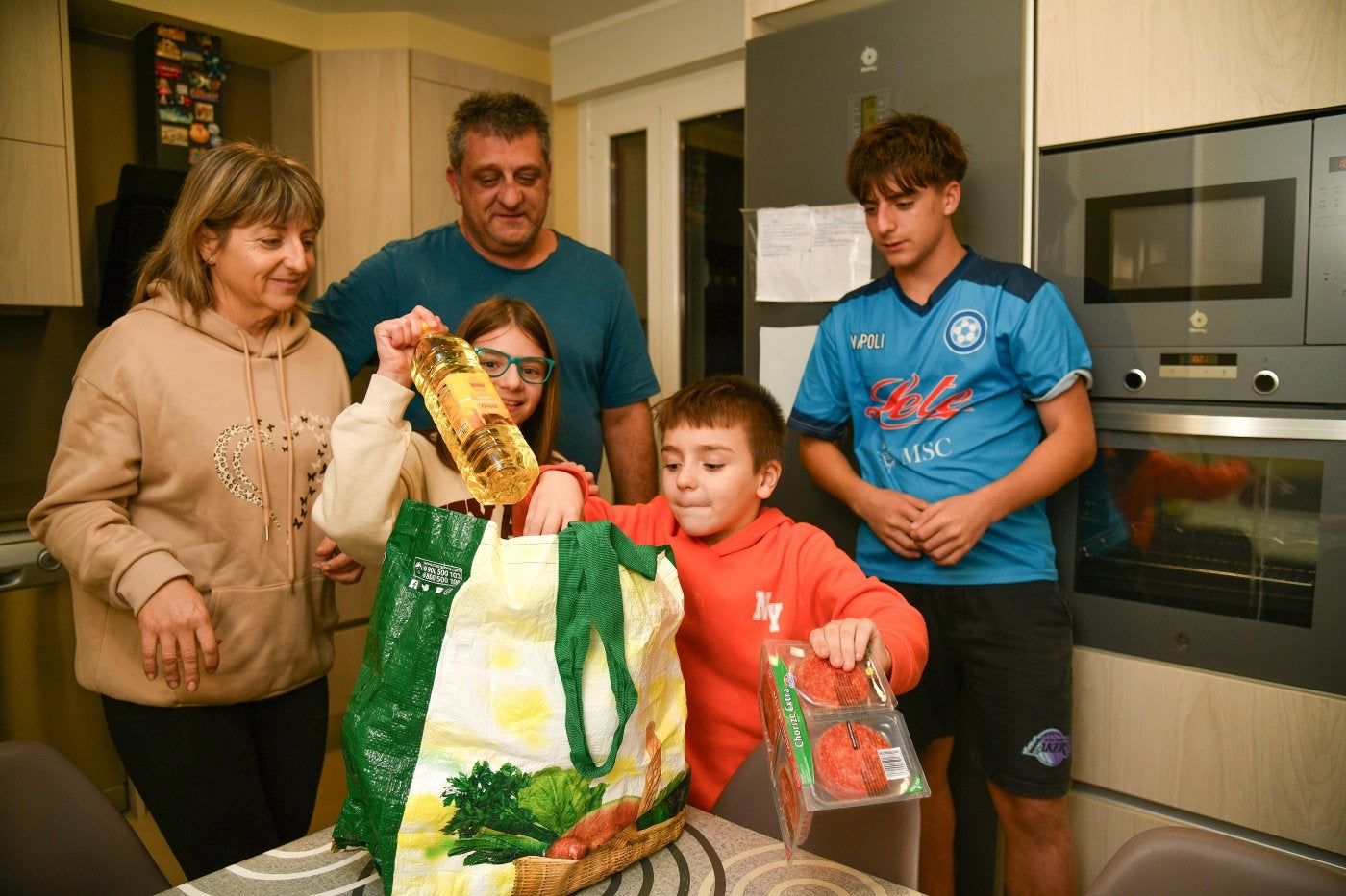 Silvia Grande recoge la compra junto a su familia en la cocina de su casa, en Ordizia.