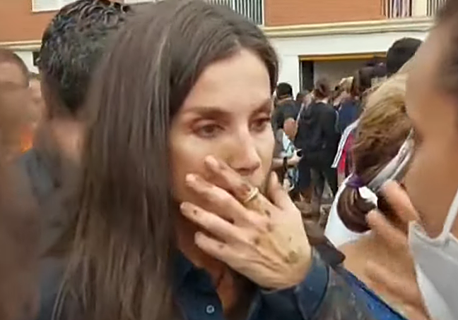 La Reina Letizia, con la mano cubierta de barro, conversa con una vecina.