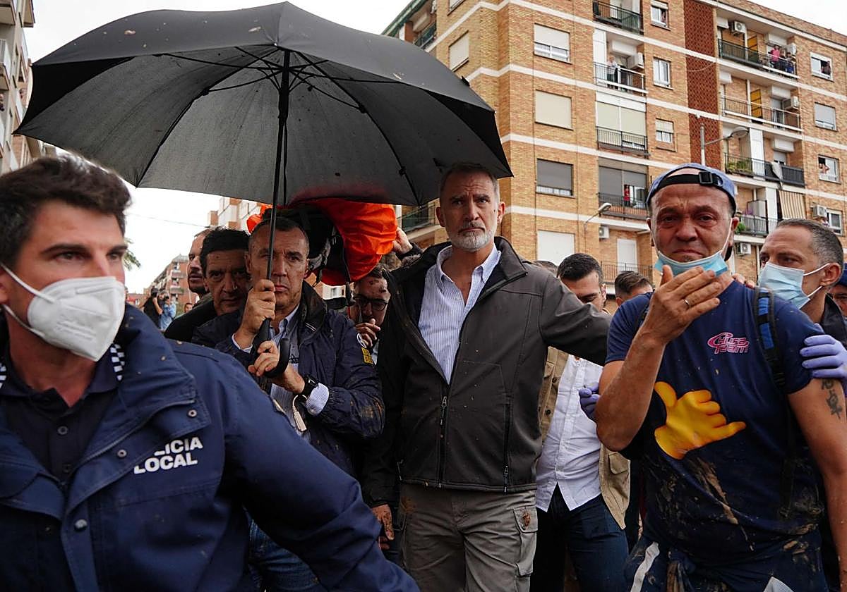 El Rey Felipe VI, con cara de estupefacción atiende a algunos vecinos en Paiporta.