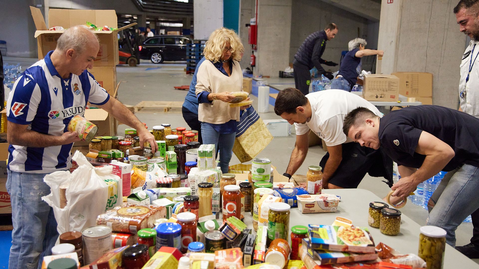 Imagen principal - Varios jugadores de la Real participan en la recogida de alimentos en el Reale Arena