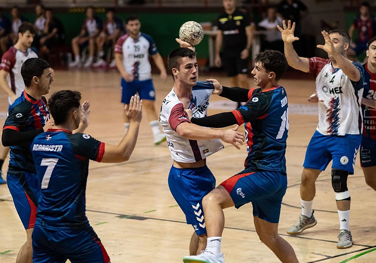Un jugador del Mek Eibar arma el brazo ante la defensa de un rival.