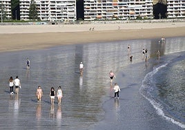 Un grupo de personas pasea por la orilla de la playa de Hondarribia.