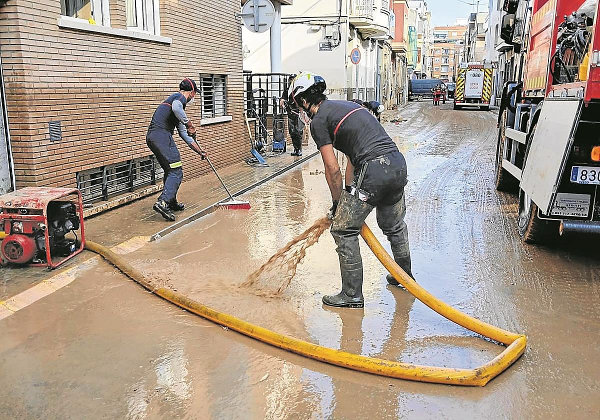 Dos miembros de los bomberos de Donostia, en plena tarea de limpieza.