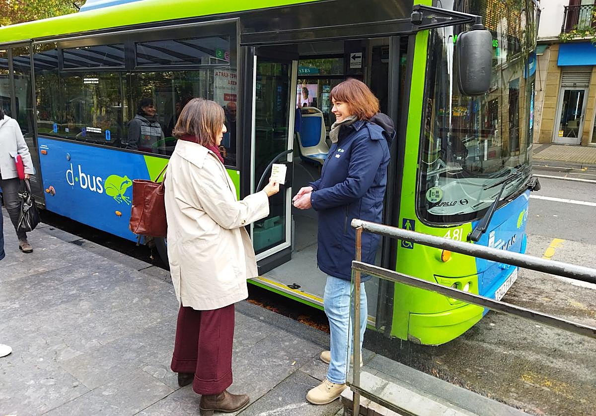 Una de las personas contratadas por Dbus para esta campaña informativa presentando el objetivo de la iniciativa a una usuaria.