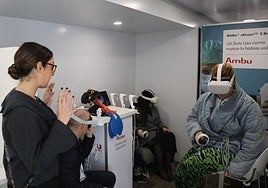 Tres visitantes prueban las gafas de realidad virtual dentro del camión.
