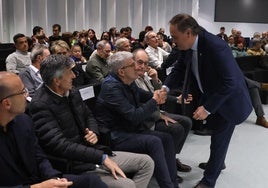 Jokin Aperribay estrecha la mano de Roberto Olabe ante la mirada de Imanol Alguacil.