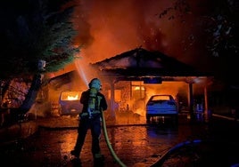 Un bombero sofocando las llamas ayer por la noche.