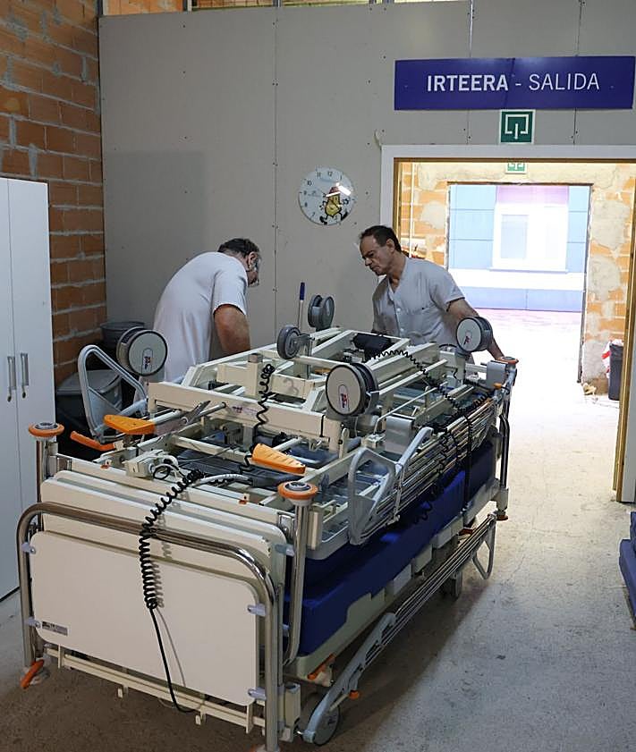 Imagen secundaria 2 - Trabajadores del Hospital Donostia colaboran para preparar las camas antes de ser transportadas. 