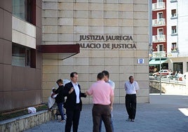 Un grupo de personas conversa frente al Palacio de Justicia de Eibar.