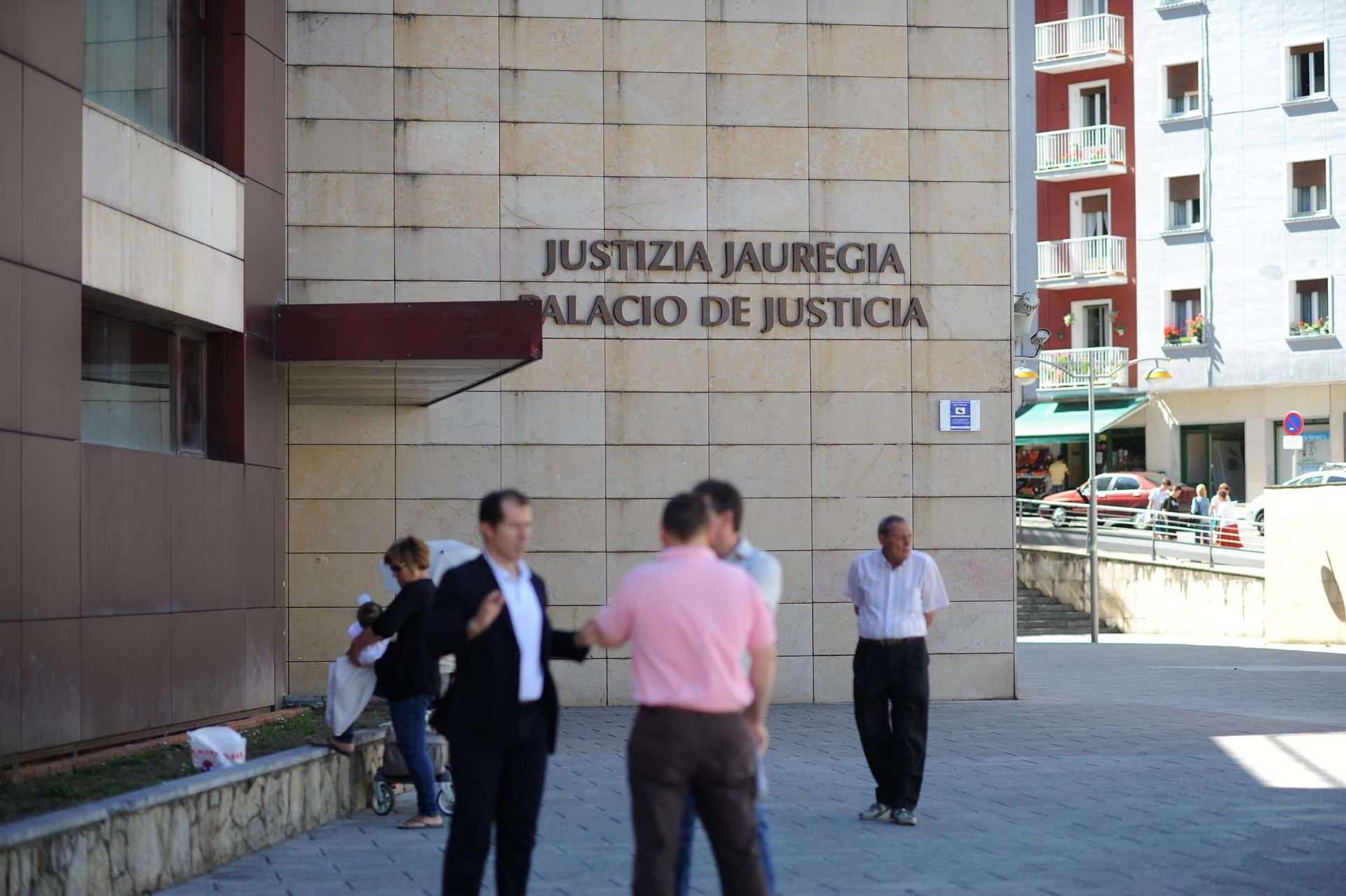 Un grupo de personas conversa frente al Palacio de Justicia de Eibar.