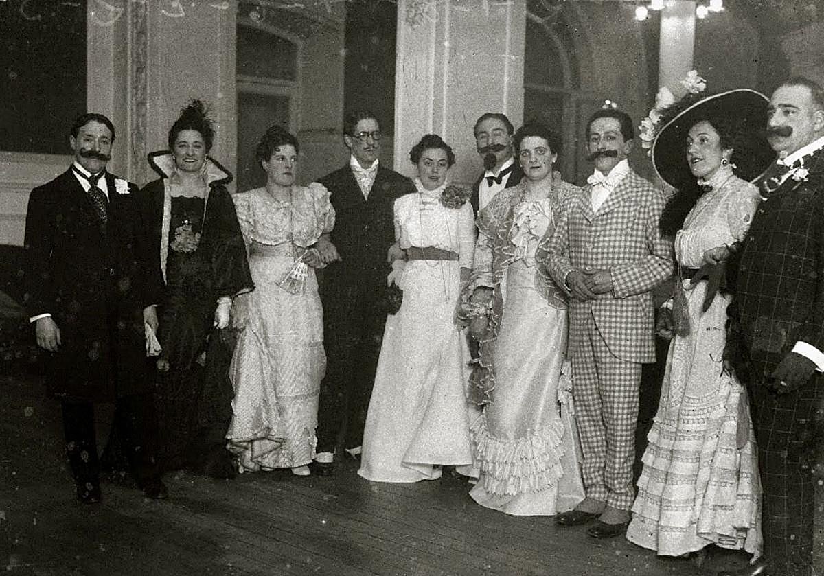 Imagen principal - Arriba, Landi, Valverde, Cabanas, Garrido y Bueno, entre otros, en una fiesta de disfraces en el Casino. En el medio, el periodista Rafael Sánchez Mazas, asomado al púlpito desde el que se daban los discursos en GU. Debajo, Eduardo Lagarde y Jesús Olasagasti, delante de los murales realizados por el primero de ellos en el Gran Casino.