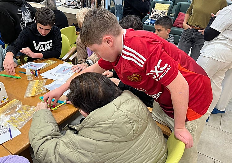 Un chaval ayuda a un persona mayor dentro de la iniciativa.