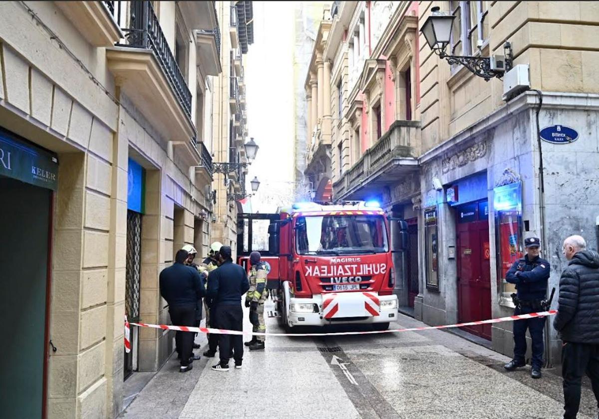 Ertzaintas y bomberos en el exterior del Bar Antonio, donde se ha originado el fuego.