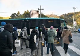 Un grupo de personas espera un autobús de Lurraldebus en Deba.