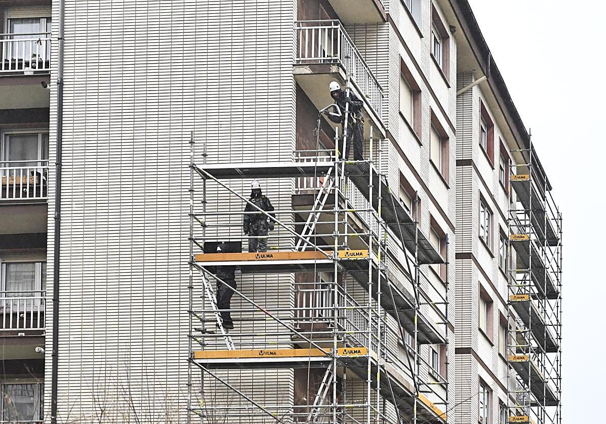 Unos obreros colocan un andamio en un edificio de Zarautz.