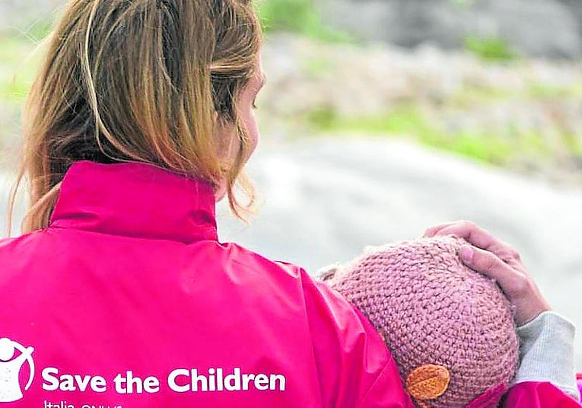 Una voluntaria de Save the Children, junto a una niña.